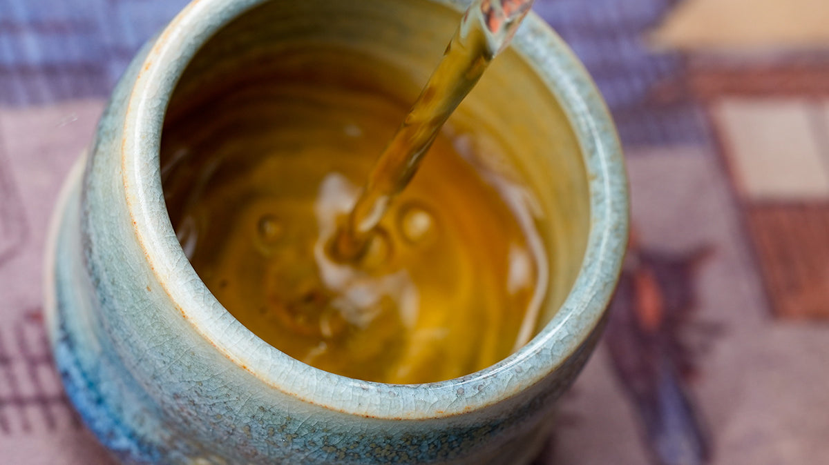 Pouring tea into a small teacup