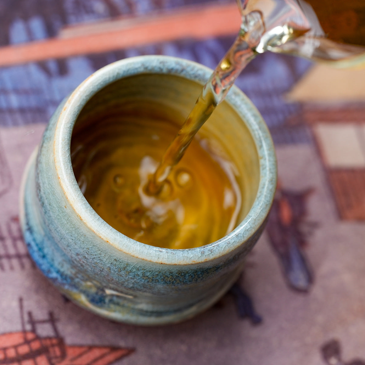 Pouring tea into a small teacup